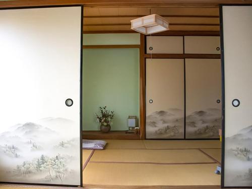 a room with two glass doors with a bed in it at Guest Cafe Kuchikumano in Kamitondacho