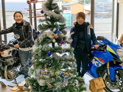 a young boy standing next to a christmas tree with a motorcycle at Guest Cafe Kuchikumano in Kamitondacho