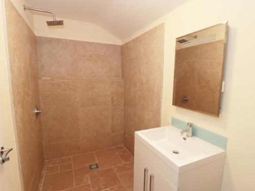 a bathroom with a shower and a sink at Bowler Yard Cottage in Sookholme