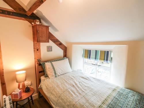 Hognaston的住宿－The Ivy Barn，一间卧室设有一张床和一个窗口