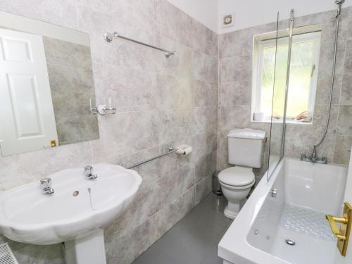 a white bathroom with a sink and a toilet at Upper Highlees Farm in Luddenden Foot