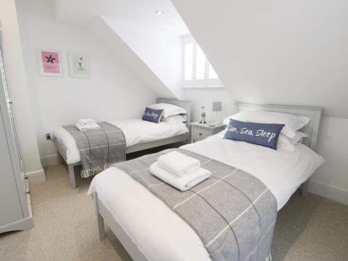 a bedroom with two beds with towels on them at Chine Cottage in Sandsend