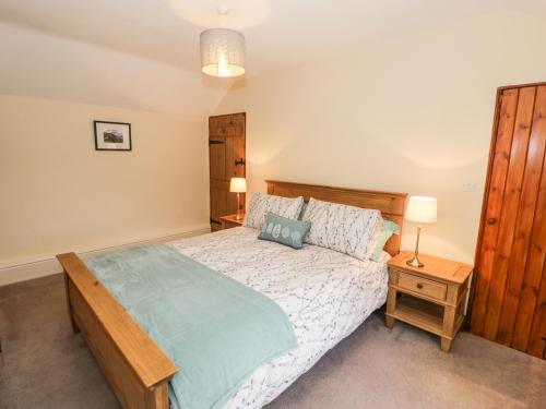 a bedroom with a large bed with a wooden headboard at Llwyn Celyn in Llanfachreth