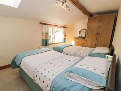 a bedroom with three beds and a window at Yr Hen Dy in Ffestiniog