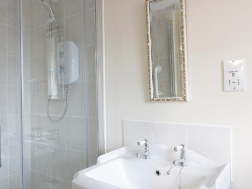 a white bathroom with a sink and a shower at Broadway Lands Farm in Little Dewchurch