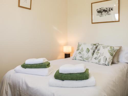 a bedroom with a bed with towels on it at Clun Forest Cottage in Monkhopton