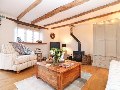 a living room with a wooden coffee table and a fireplace at Polly's Bower in Landrake