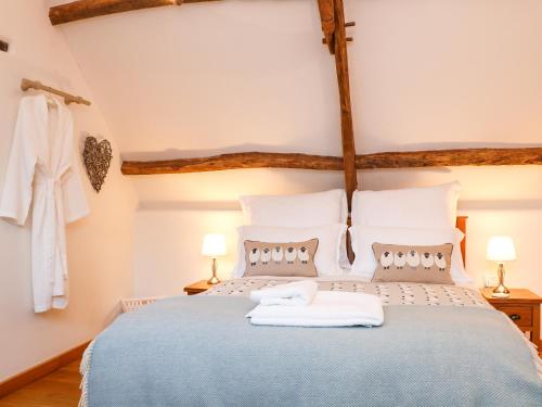a bedroom with a blue bed with two towels on it at Polly's Bower in Landrake