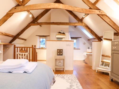 a bedroom with a bed in a room with exposed beams at Polly's Bower in Landrake