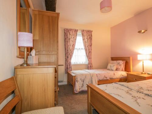 a hotel room with two beds and a window at Ale Cottage in Ireby