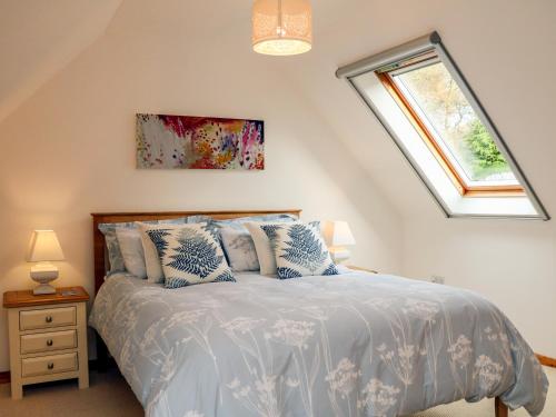 a bedroom with a bed with blue and white sheets at Cross Syke Barn in Shirwell