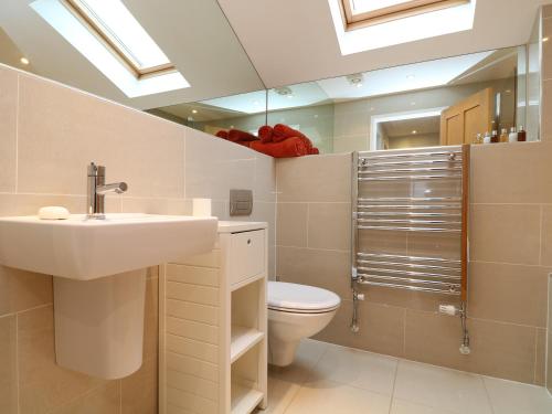 a bathroom with a sink and a toilet and a mirror at Chy Kerris, Carbis Bay in Carbis Bay