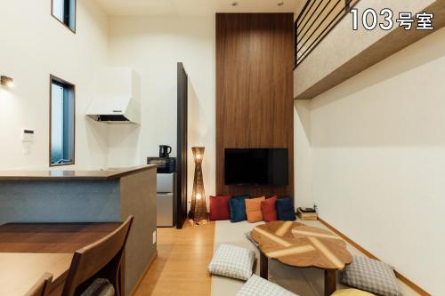 sala de estar con sofá y mesa en YOUR ROOM 熊本駅, en Kumamoto