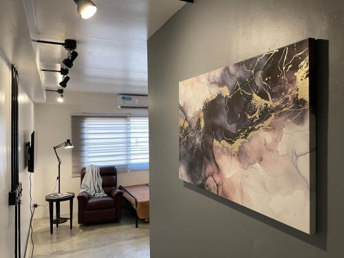 a living room with a painting hanging on the wall at CRIB 253 Subic Bay in Olongapo