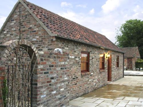 ein Backsteingebäude mit einem Tor davor in der Unterkunft Lodge Cottage in York