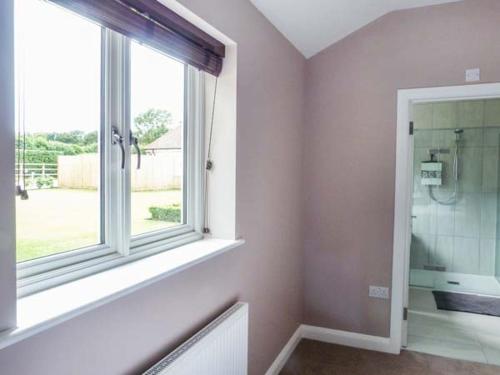 a bathroom with a window and a walk in shower at Willow Lodge in Canterbury