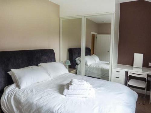 カンタベリーにあるWillow Lodgeのベッドルーム1室(白いベッド1台、タオル付)
