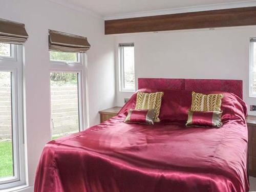 a bedroom with a large pink bed with two pillows at Westview in Weston-super-Mare