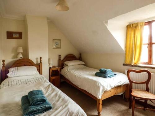 a bedroom with two beds with towels on them at Kingsley Cottage in Hickling