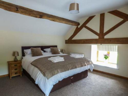 a bedroom with a large bed and a window at The Hayloft in Oswestry