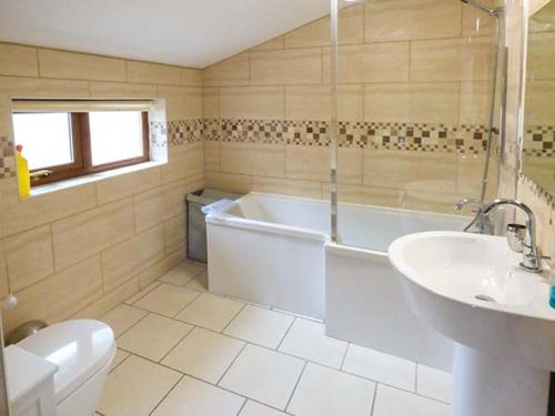 ein Badezimmer mit einer Badewanne, einem WC und einem Waschbecken in der Unterkunft Y Bwthyn in Ystrad Meurig