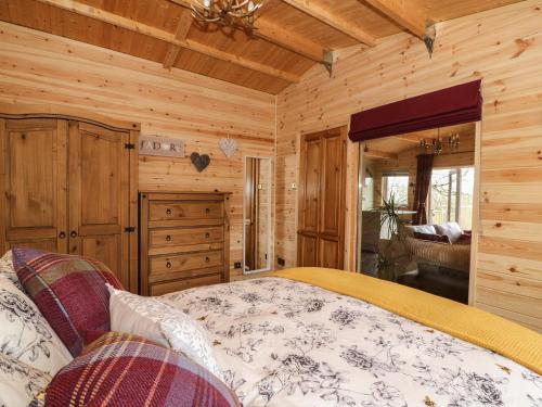 a bedroom with a bed in a wooden cabin at The Cabin in Garnant