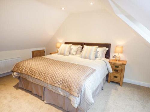 Manor Barn في Fulford: غرفة نوم بسرير كبير في العلية