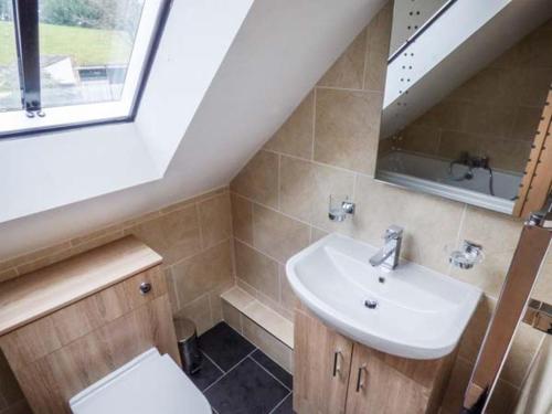 a bathroom with a sink and a toilet and a window at Manor Barn in Fulford