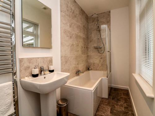 Un baño blanco con lavabo y bañera. en Valley View, en Ilfracombe