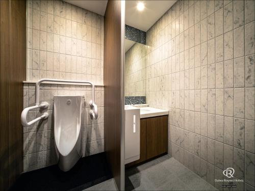 a bathroom with a urinal and a sink at Daiwa Roynet Hotel Yamagata Ekimae in Yamagata