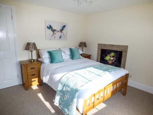 a bedroom with a large bed with blue pillows at Mill Cottage in Wolsingham