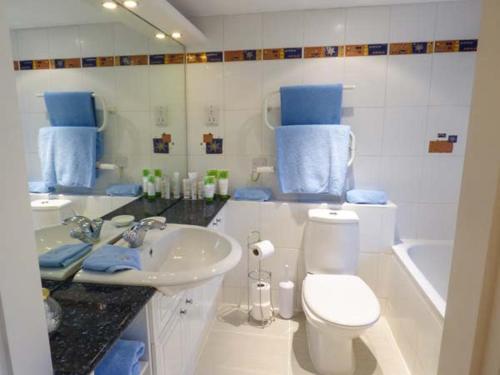 een badkamer met een wastafel, een toilet en een bad bij Pheasant Cottage in Grange Over Sands