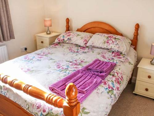 a bedroom with a large bed with flowers on it at Primrose Cottage in Alford