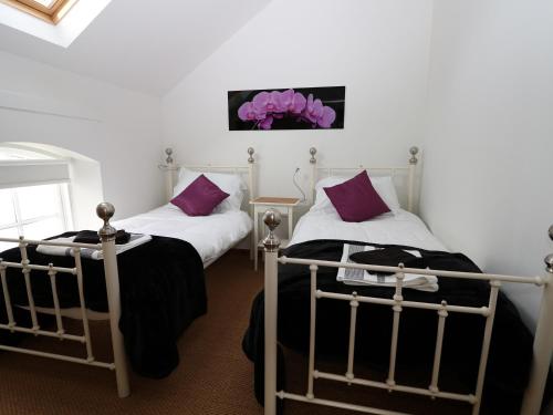 Duas camas num quarto com almofadas roxas em Old Chapel em Scarborough