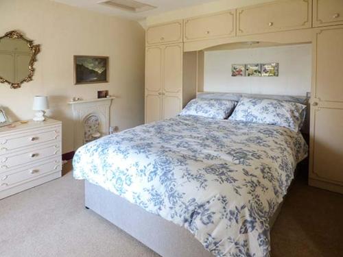 a bedroom with a bed with a blue and white comforter at Church View in Hartington