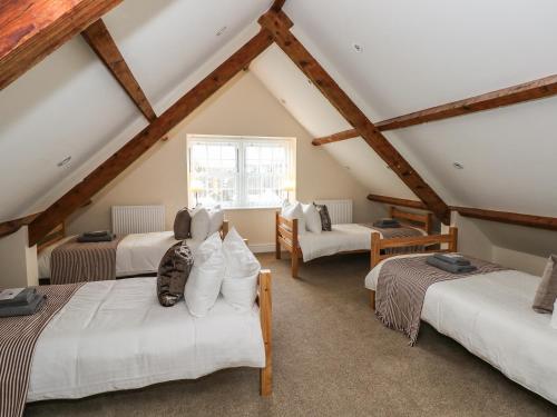 a attic room with three beds and a window at Hideaway House at The Hideaway in Tenby