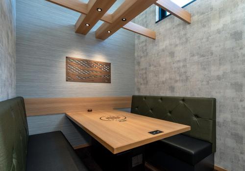 a dining room with a wooden table and two chairs at Daiwa Roynet Hotel Yamagata Ekimae in Yamagata