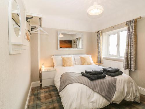Un dormitorio con una cama con toallas. en The Beach House Criccieth, en Criccieth