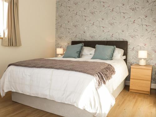 a bedroom with a bed with two blue pillows at Swallow Barn in Walford