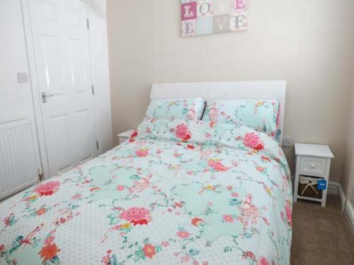 a bedroom with a bed with a floral bedspread at Flat 3 in Bridlington