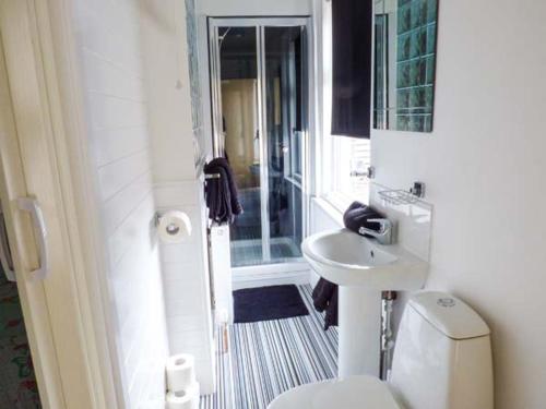a bathroom with a toilet and a sink and a shower at Flat 3 in Bridlington