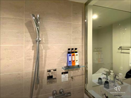a bathroom with a shower and a sink and a mirror at Daiwa Roynet Hotel Yamagata Ekimae in Yamagata