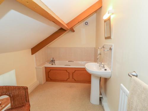 a bathroom with a sink and a bath tub at Garden Cottage in Mickleton
