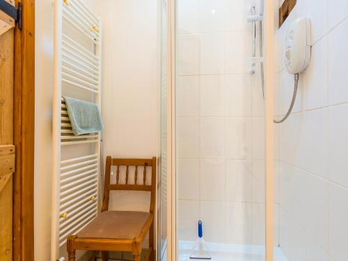 a small bathroom with a shower and a wooden chair at The Byre in Highley