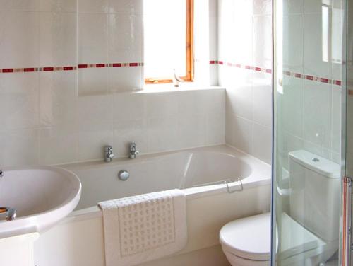 ein Badezimmer mit einer Badewanne, einem WC und einem Waschbecken in der Unterkunft The Roost in Stratford-upon-Avon