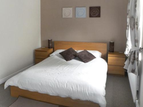 a bedroom with a white bed with two pillows at River Cottage in Staithes