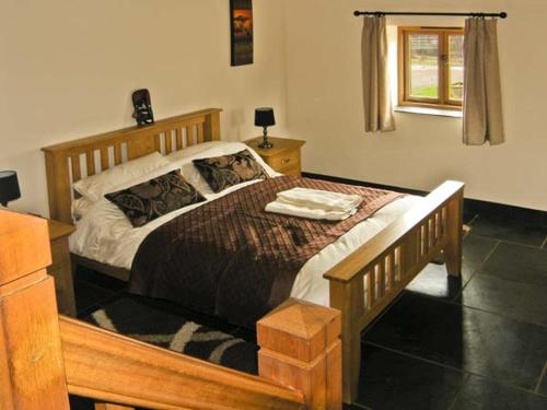 a bedroom with a large bed with a wooden frame at The Byre in Abergavenny