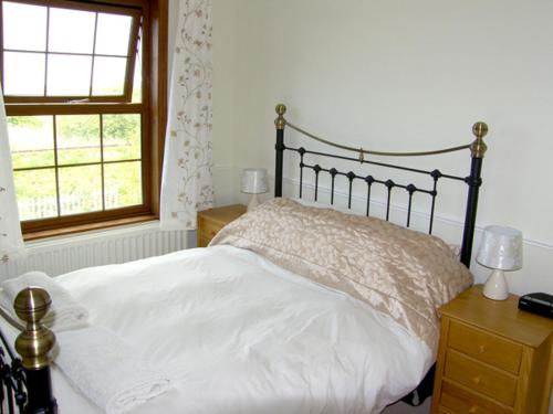 フェアボーンにあるRailway Cottageのベッドルーム(白いベッド1台、窓付)