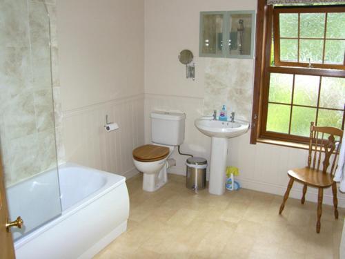 ein Badezimmer mit Badewanne, Toilette und Waschbecken in der Unterkunft Railway Cottage in Fairbourne