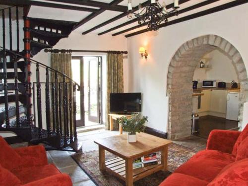 ein Wohnzimmer mit Sofa und Tisch in der Unterkunft The Cottage in Buxton